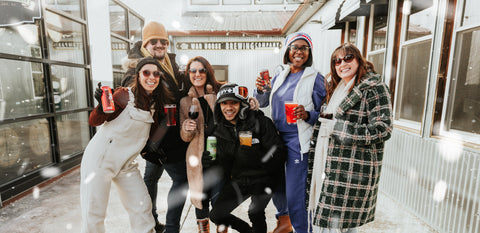 Group of people posing together in a snowy outdoor setting at Three Brothers Wineries