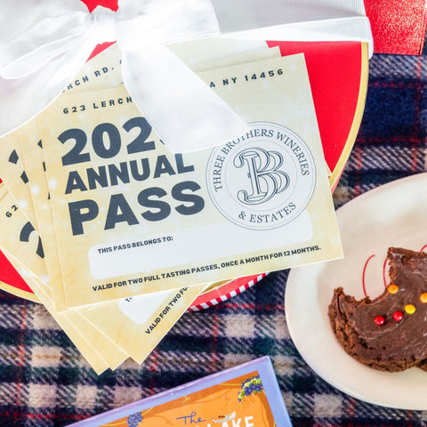 Three Brothers Wineries & Estates annual pass with cookies on a plaid tablecloth
